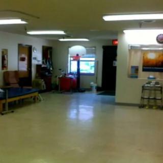 A spacious waiting room with chairs and bright fluorescent lighting.