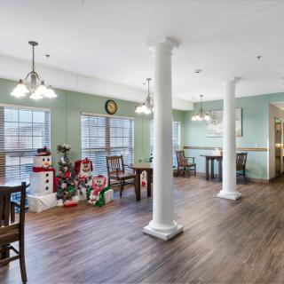 A spacious dining area with elegant columns, filled with natural light from large windows.