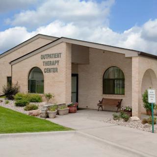 The exterior of a modern therapy center with well-maintained landscaping.