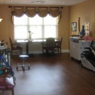 A cozy room with office equipment and seating area by a large window.