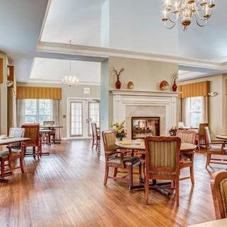 A bright and spacious dining area with a fireplace and elegant furnishings.