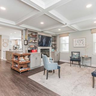 A stylish living room featuring a coffered ceiling, fireplace, and modern furniture.