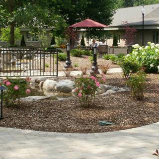A beautifully landscaped garden with a pathway, flowers, and outdoor seating area.