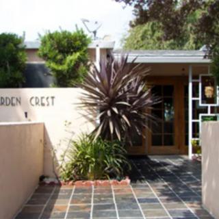 A modern house entrance with a tiled pathway and decorative plants.
