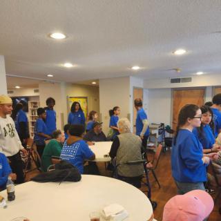 A community gathering taking place indoors with people interacting.
