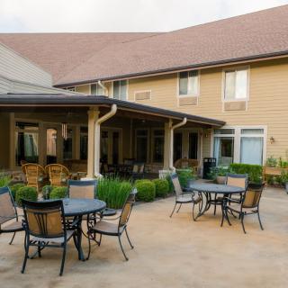 Outdoor patio area with tables and chairs in front of a building.