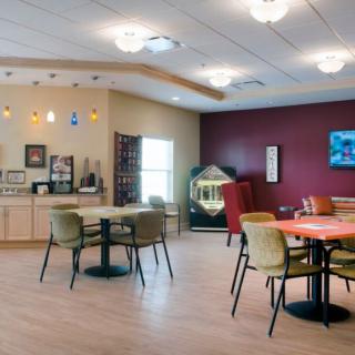 A cozy dining area featuring tables, chairs, and ambient lighting with a jukebox in the corner.