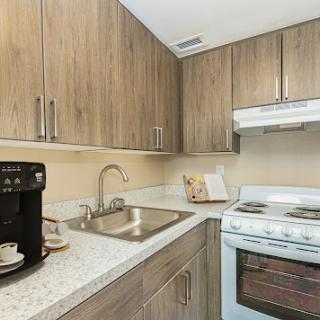 A modern kitchen featuring wooden cabinets, a stainless steel sink, and essential appliances.