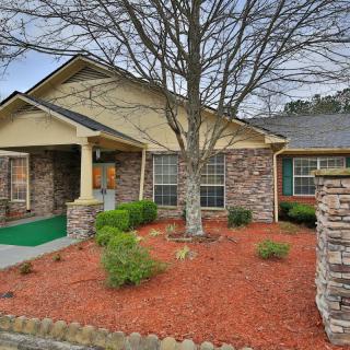 A cozy brick house with a small front yard and tree.