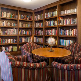 A cozy library corner featuring bookshelves filled with books and a comfortable seating area.