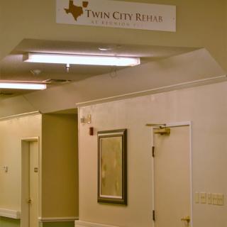 A hallway interior with a Twin City Rehab sign above the door.