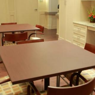 An empty dining area featuring wooden tables and chairs.