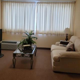 A cozy living room with a sofa, coffee table, and television.