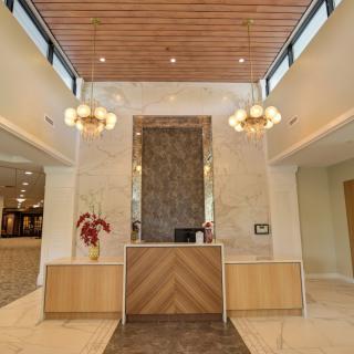 A modern reception area featuring a wooden desk and stylish lighting.