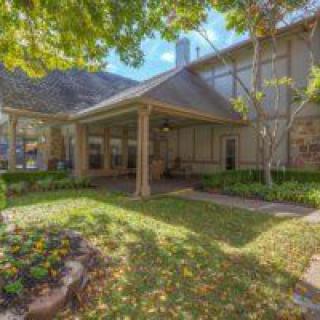 A charming house with a well-maintained garden and shaded porch.
