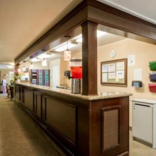 A hotel reception area with a wooden desk and various amenities.
