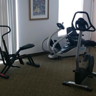 A small gym setup with various exercise machines.