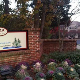 A welcoming sign outside a healthcare facility, surrounded by vibrant landscaping.