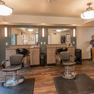 A modern hair salon with two styling stations featuring mirrors and chairs.