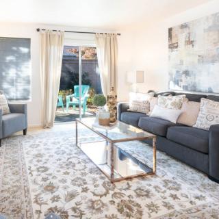 A modern living room with a stylish sofa, glass coffee table, and elegant decor leading to an outdoor patio.