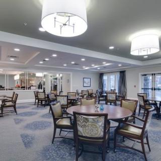 A well-lit dining area with arranged tables and chairs, showcasing elegant interior design.