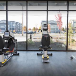 A modern gym room featuring stationary bikes with a view through large windows.