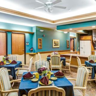 A stylish dining room with neatly arranged tables and chairs, featuring elegant decor and ambient lighting.