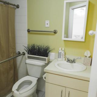 A compact bathroom with a toilet, sink, mirror, and shower curtain.