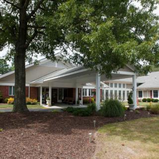 A suburban house surrounded by trees and landscaping.