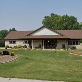 A suburban house with a well-maintained front yard and surrounding trees.