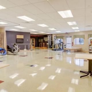 A spacious, well-lit rehabilitation center featuring exercise equipment and therapy areas.
