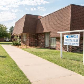 A brick law office building with a sign outside and a concrete pathway leading to the entrance.