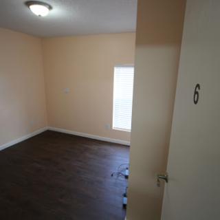 A vacant room featuring light-colored walls and a small window.
