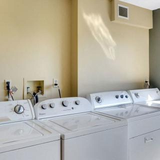 A laundry room with multiple washing machines and dryers.