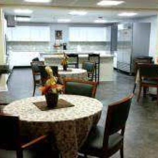 A cozy kitchen and dining area with round tables and chairs.