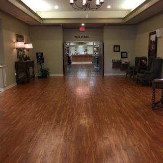 A spacious and well-lit lobby with wooden flooring, elegant furniture, and a welcoming atmosphere.