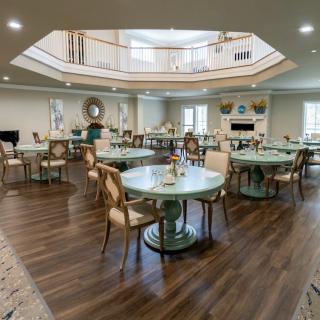 A modern dining area with round tables and elegant chairs on wooden flooring.