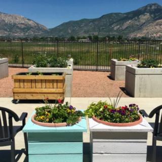 A scenic garden with planters and chairs overlooking a mountain view.