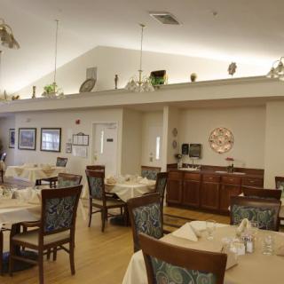 A cozy dining area with neatly arranged tables and chairs, featuring elegant decor.