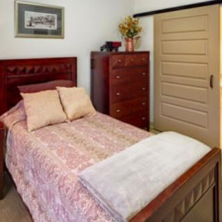 A cozy bedroom with a wooden bed, dresser, and decorative elements.