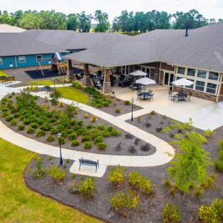 Aerial view of a building with a landscaped garden and winding pathways.