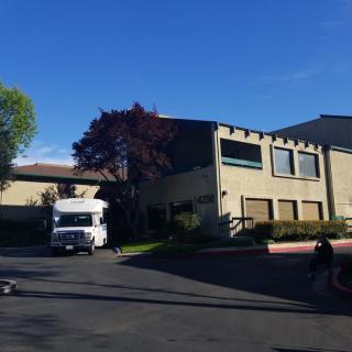A truck parked near a building on a sunny day.