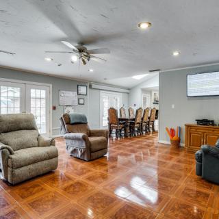 A spacious living room with hardwood flooring, featuring comfortable recliners and a dining area.