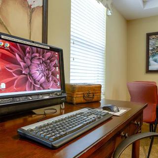 A cozy office setup with a desktop computer on a wooden desk near a window.