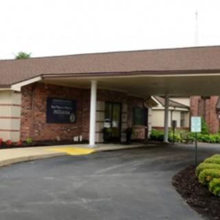 A building entrance with a covered driveway and landscaped surroundings.