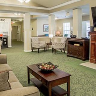 A cozy living room with comfortable seating and a television, featuring a carpeted floor and stylish decor.