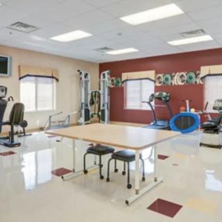 A well-equipped physical therapy room with various exercise machines and rehabilitation tools.