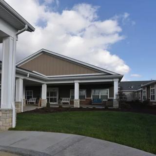 A residential building with a well-maintained lawn under a partly cloudy sky.