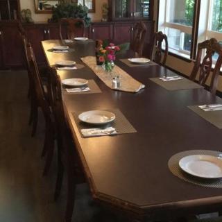 A dining room with a long table set for a meal.