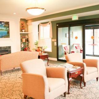 A cozy lobby area with comfortable chairs and a small table, featuring warm lighting and decorative elements.